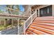 Welcoming front entrance with wooden steps and white railings leading to a stylish, dark-colored front door at 9934 Peninsular Dr, Gibsonton, FL 33534