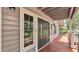 Front porch with a stylish front door, large window, and stained wood deck at 9934 Peninsular Dr, Gibsonton, FL 33534