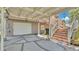 Garage and outdoor parking area of home with geometric patterned concrete blocks and stair access to the first floor at 9934 Peninsular Dr, Gibsonton, FL 33534