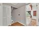 Hallway featuring wood floors, leading to upstairs and adjacent to a cozy living room with balcony access at 9934 Peninsular Dr, Gibsonton, FL 33534