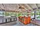 Covered outdoor patio featuring an outdoor kitchen, ceiling fans, and bar at 9934 Peninsular Dr, Gibsonton, FL 33534
