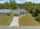 Stunning aerial view showcasing the home's layout, manicured lawn, and proximity to neighboring houses and lush greenery at 3157 Bay City Ter, North Port, FL 34286