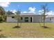 Expansive backyard featuring a white modern home with a covered patio and newly planted trees at 3157 Bay City Ter, North Port, FL 34286