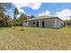 Spacious backyard showcasing a modern home with a well-maintained lawn and sleek, contemporary design at 3157 Bay City Ter, North Port, FL 34286