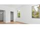 Bright bedroom with wood floors, two windows, and closet and bathroom entrances at 3157 Bay City Ter, North Port, FL 34286