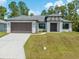 Beautiful single-story home featuring a two-car garage and modern architectural details, surrounded by a lush green lawn at 3157 Bay City Ter, North Port, FL 34286