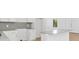 Modern kitchen with white cabinets, an island with light gray countertops, and stainless steel appliances, offering sleek functionality at 3157 Bay City Ter, North Port, FL 34286