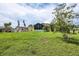 Large grassy backyard with shed and screened patio at 12209 Cotorro Ave, North Port, FL 34287