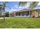 Cute yellow house with screened porch and nicely landscaped lawn at 12209 Cotorro Ave, North Port, FL 34287