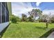 Large backyard with lush grass, mature trees, and a shed at 12209 Cotorro Ave, North Port, FL 34287