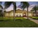 House exterior with palm trees and manicured lawn at dusk at 12209 Cotorro Ave, North Port, FL 34287