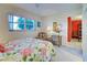 Inviting bedroom showcasing a floral bedspread, a sunlit window with view, and a comfortable seating area at 244 Saint Augustine Ave # 203, Venice, FL 34285
