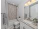 Clean bathroom with granite vanity, neutral tile, and a bathtub shower combo at 922 E Venice Ave, Venice, FL 34285