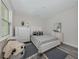 Bright bedroom with white furniture, patterned bedding, and a cozy armchair at 922 E Venice Ave, Venice, FL 34285