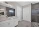 Elegant bathroom with white cabinets, quartz countertop, and a large walk-in shower at 21220 Holmes Cir, Venice, FL 34293