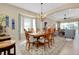 Bright dining room with chandelier, natural light, and stylish furniture, perfect for entertaining guests at 11065 Barnsley Dr, Venice, FL 34293