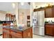 Kitchen island with stainless steel fridge and granite countertop offers sleek design and functionality at 11065 Barnsley Dr, Venice, FL 34293