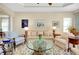 Bright living room features comfy seating, a glass coffee table, and tasteful artwork at 11065 Barnsley Dr, Venice, FL 34293
