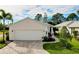 Single-story home with white garage door and landscaped yard at 11065 Barnsley Dr, Venice, FL 34293