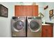 Bright laundry room, featuring a washer, dryer, and cabinets at 11065 Barnsley Dr, Venice, FL 34293