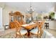 Elegant dining room with a large wooden table, hutch, and chandelier at 11065 Barnsley Dr, Venice, FL 34293