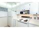 White kitchen with stove, microwave and refrigerator at 454 Cerromar Rd # 275, Venice, FL 34293
