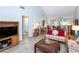 Living room with floral couches, wood coffee table, and view of kitchen and bathroom at 454 Cerromar Rd # 275, Venice, FL 34293