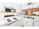Bright kitchen features white cabinets, stainless steel sink, and electric range at 454 Cerromar Rd # 275, Venice, FL 34293