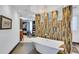 Elegant bathroom with a freestanding tub, decorative tile accent wall, and an open-concept closet at 361 Benjamin Franklin Dr # A, Sarasota, FL 34236
