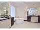 Bright bathroom boasts a freestanding tub, dual sinks, and contemporary lighting fixtures at 361 Benjamin Franklin Dr # A, Sarasota, FL 34236