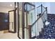 Interior view showcasing a glass elevator and elegant staircase with patterned carpet at 361 Benjamin Franklin Dr # A, Sarasota, FL 34236