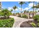 Gated entrance with lush tropical landscaping, pavers, and palm trees on a sunny day at 361 Benjamin Franklin Dr # A, Sarasota, FL 34236