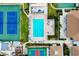 Aerial view of community pool, tennis courts, and surrounding buildings at 744 White Pine Tree Rd # 103, Venice, FL 34285