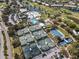 Aerial view of a community with many tennis courts, pool, and golf course with tropical landscaping and ponds at 266 Cerromar S Way # 55, Venice, FL 34293
