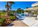 Beautiful community pool area featuring lounge chairs, covered seating, and tropical landscaping at 266 Cerromar S Way # 55, Venice, FL 34293
