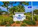 Augusta Villas entrance with lush landscaping, mature trees, and community signage at 266 Cerromar S Way # 55, Venice, FL 34293