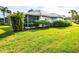 Back exterior view of house with screened porch, landscaping, and manicured lawn at 266 Cerromar S Way # 55, Venice, FL 34293