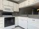 The kitchen features white cabinets, granite countertops, and modern appliances at 266 Cerromar S Way # 55, Venice, FL 34293