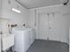 Laundry room with utility sink, washer, dryer, and access to storage at 266 Cerromar S Way # 55, Venice, FL 34293