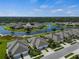 Picturesque aerial view of a community with beautiful landscaping, a pond, and well-maintained homes at 3525 Lakewood Blvd, North Port, FL 34287