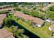 A sunny, high-angle view of the condo community with manicured lawns and a flowing waterway at 756 White Pine Tree Rd # 204, Venice, FL 34285