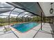 An inviting screened-in in-ground pool with chairs and room for entertaining or just relaxing at 1061 Owl Dr, Englewood, FL 34223