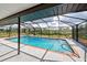 An inviting screened-in in-ground pool with chairs and room for entertaining and relaxing at 1061 Owl Dr, Englewood, FL 34223