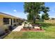 Landscaped backyard featuring a patio with outdoor furniture, a grill, and flourishing flower beds at 566 Viridian St, Englewood, FL 34223