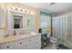 Bright bathroom featuring a white vanity, toilet, and shower with floral curtain at 566 Viridian St, Englewood, FL 34223