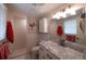 Clean bathroom with a shower, toilet, and vanity with marble countertop, providing a functional space at 566 Viridian St, Englewood, FL 34223