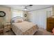 Bright bedroom featuring a floral quilt, white wicker headboard, and a ceiling fan at 566 Viridian St, Englewood, FL 34223