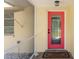 A vibrant pink front door, neutral walls, and tiled porch at 566 Viridian St, Englewood, FL 34223