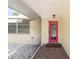 A covered porch featuring a vibrant pink door, neutral walls, and a tiled floor at 566 Viridian St, Englewood, FL 34223