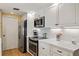 Well-equipped kitchen featuring stainless steel appliances, elegant white cabinets, and ample counter space for meal preparation at 566 Viridian St, Englewood, FL 34223
